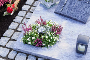 Urnengrab mit Grabplatte, Kissenstein und Bepflanzung