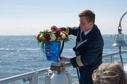 Benjamin Albrecht von der Seebestattungs-Reederei Albrecht lässt eine Seeurne feierlich zu Wasser.