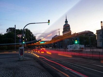 Straße in Darmstadt mit Ampeln und einem Glockenturm im Hintergrund